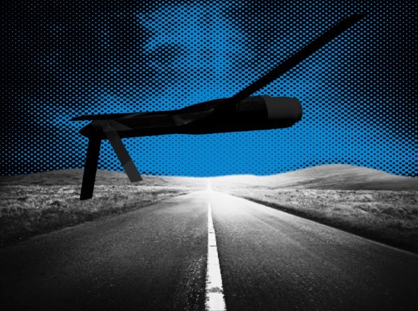 A silhouette of a missile against a landscape and road background